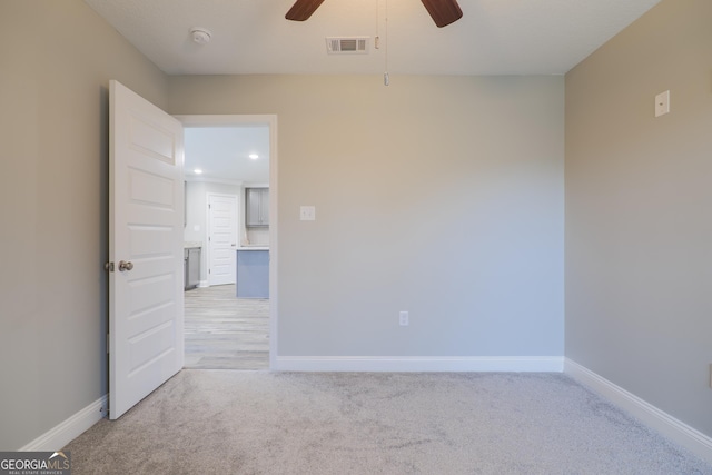 unfurnished room with baseboards, visible vents, ceiling fan, and light colored carpet