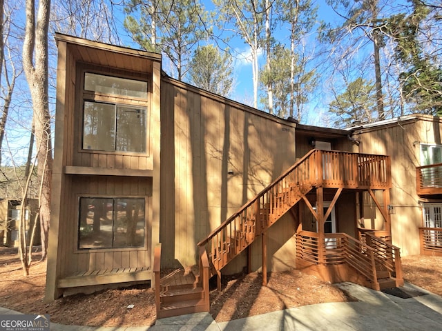 rear view of property with stairway and a wooden deck