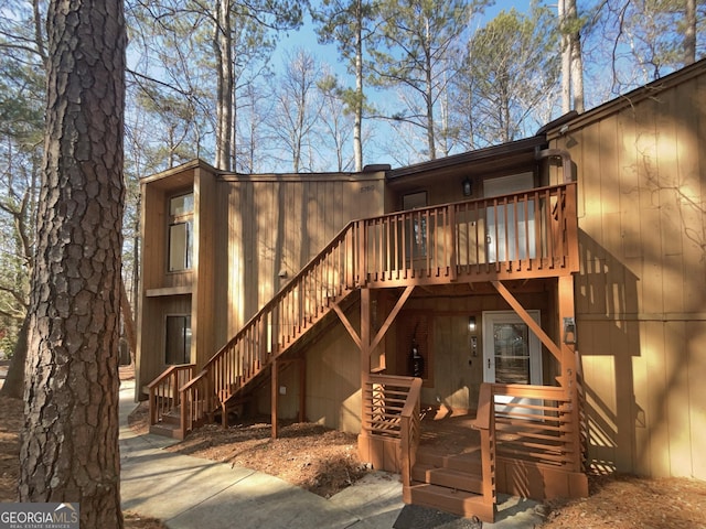 back of property with stairs and a deck