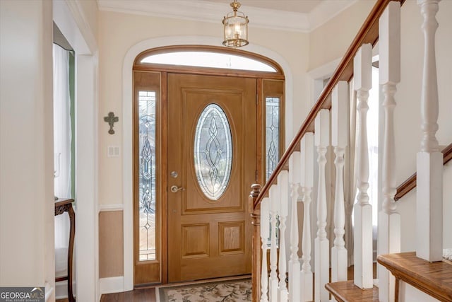 entryway with a healthy amount of sunlight, stairs, and ornamental molding