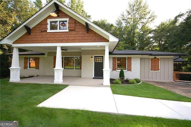 view of front of property featuring board and batten siding, a front yard, and covered porch