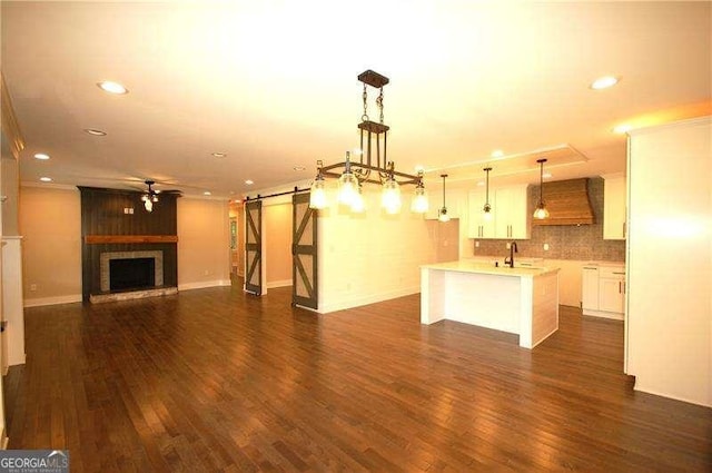 kitchen featuring white cabinets, open floor plan, light countertops, and decorative light fixtures