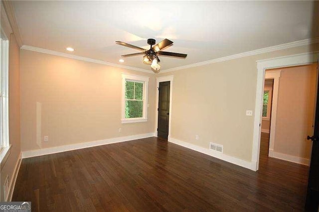 unfurnished room with dark wood-style flooring, visible vents, crown molding, and baseboards