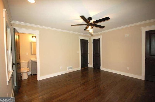 unfurnished bedroom with dark wood-type flooring, visible vents, ornamental molding, and baseboards