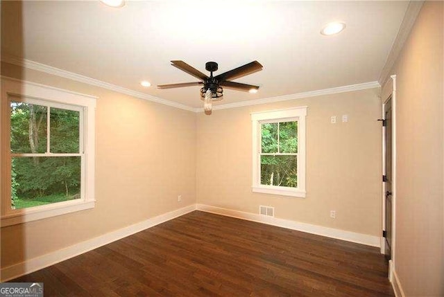 empty room featuring baseboards, dark wood finished floors, and crown molding