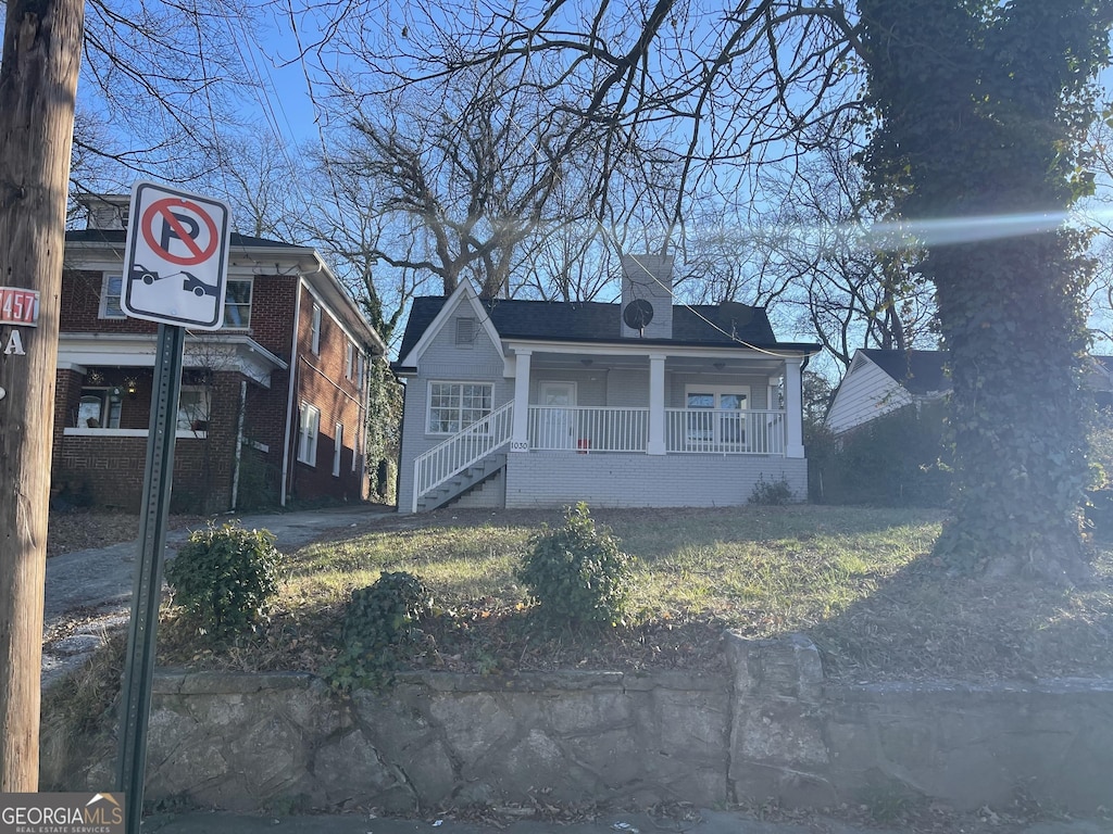 bungalow-style house with covered porch and a front lawn