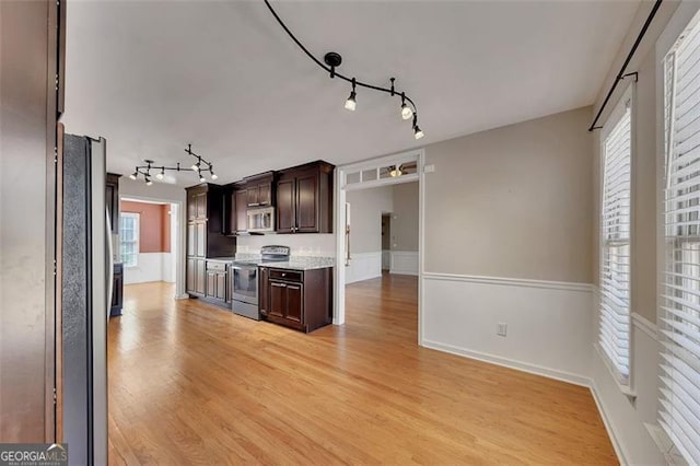 kitchen with light wood finished floors, appliances with stainless steel finishes, light countertops, dark brown cabinets, and track lighting