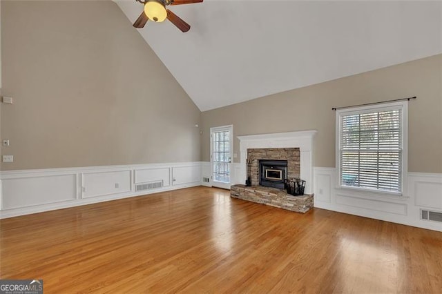 unfurnished living room with visible vents, wainscoting, a ceiling fan, and light wood-style floors