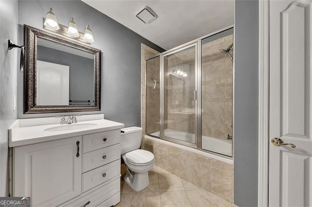 bathroom featuring tiled shower / bath, vanity, toilet, and tile patterned floors