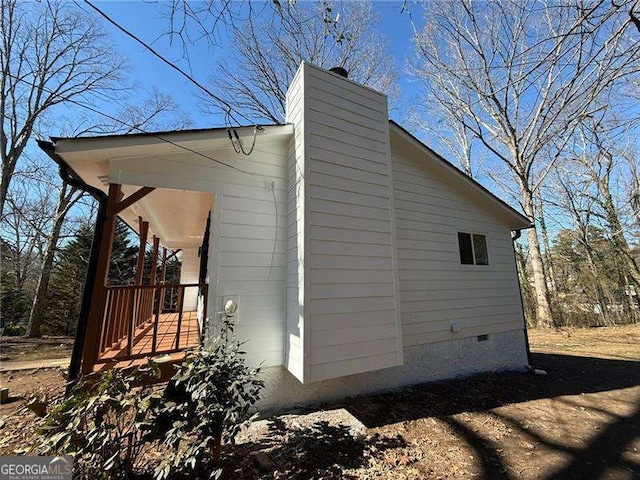 view of property exterior with crawl space and a chimney