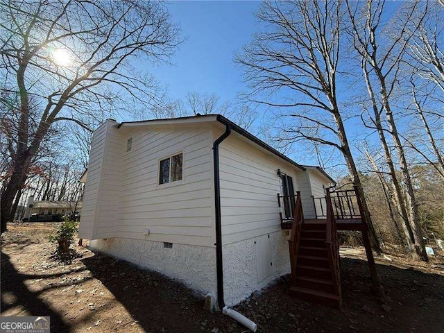 view of side of home with stairway, crawl space, and a wooden deck