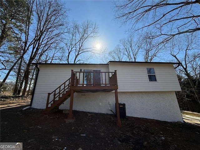 back of property featuring central air condition unit, stairs, and a deck