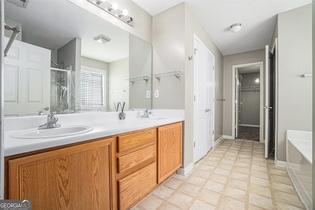 full bathroom featuring a stall shower, a sink, a bath, and tile patterned floors