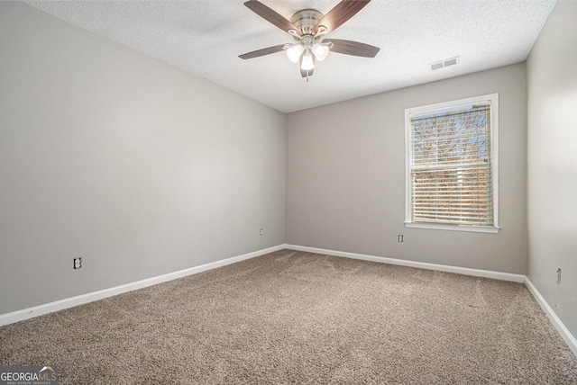 unfurnished room featuring a textured ceiling, carpet, visible vents, and baseboards