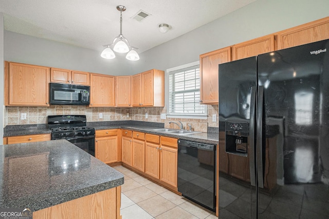 kitchen with dark countertops, visible vents, a sink, and black appliances