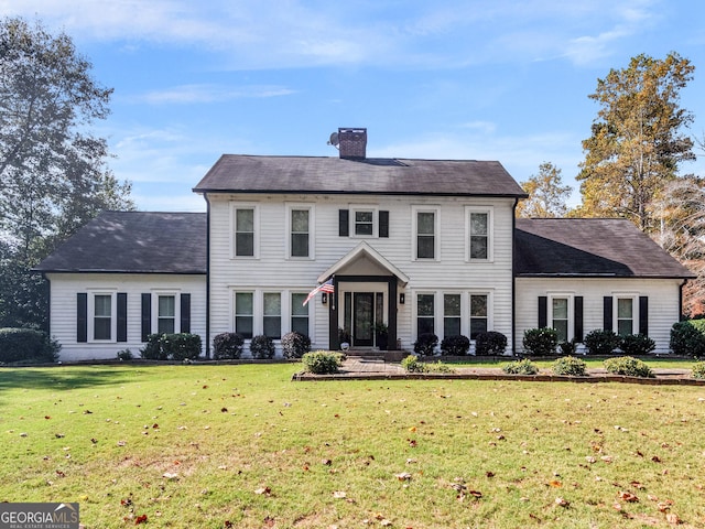 view of front of property featuring a chimney and a front lawn