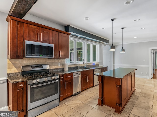 kitchen featuring stainless steel appliances, pendant lighting, a sink, and tasteful backsplash