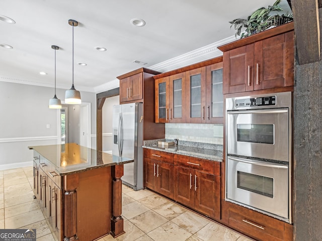 kitchen with pendant lighting, stainless steel appliances, a kitchen island, glass insert cabinets, and crown molding