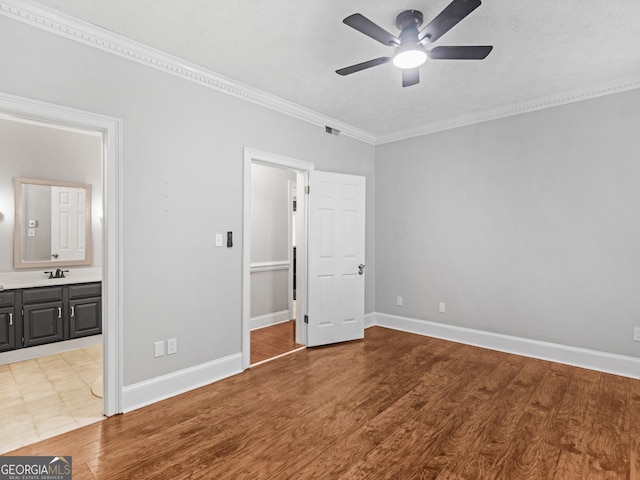 unfurnished bedroom with light wood-style flooring, visible vents, baseboards, and a sink