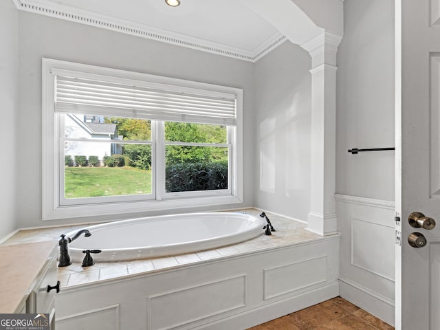 bathroom featuring ornamental molding, a bath, and ornate columns