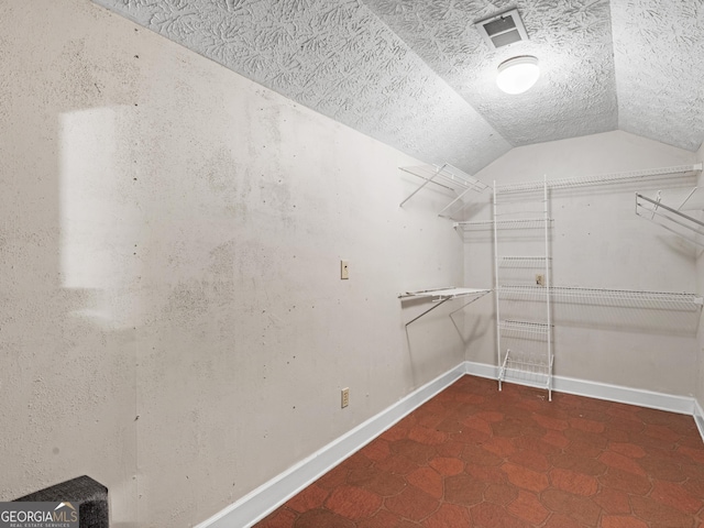 spacious closet featuring lofted ceiling and visible vents