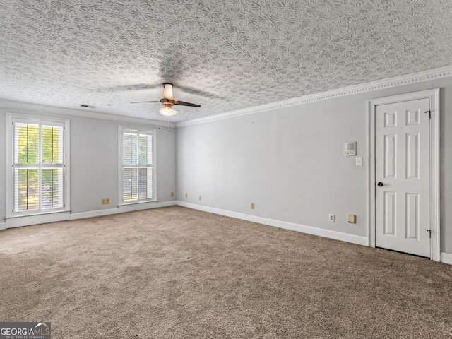 carpeted empty room with ceiling fan, a textured ceiling, visible vents, baseboards, and crown molding