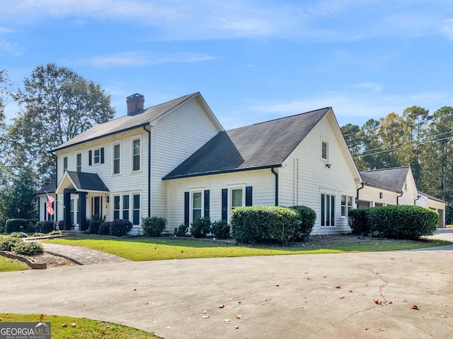 view of front of house with a chimney and a front lawn