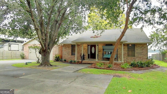 single story home with an attached garage, driveway, a front lawn, and brick siding