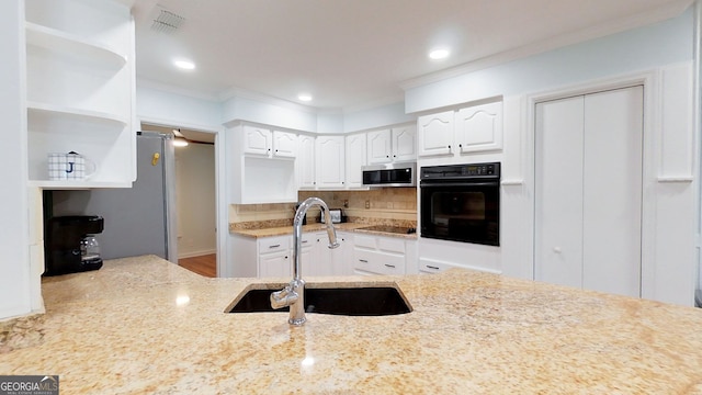 kitchen featuring open shelves, white cabinets, a sink, light stone countertops, and black appliances