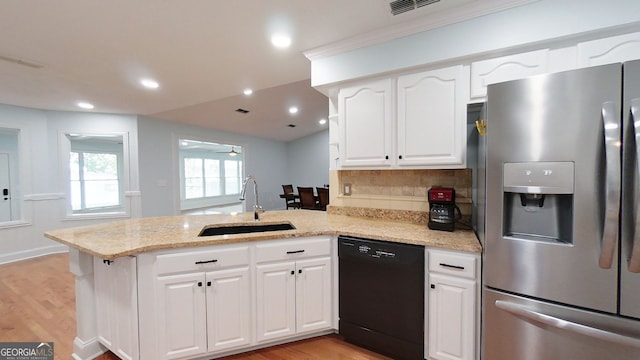 kitchen featuring black dishwasher, stainless steel fridge, a sink, and a peninsula