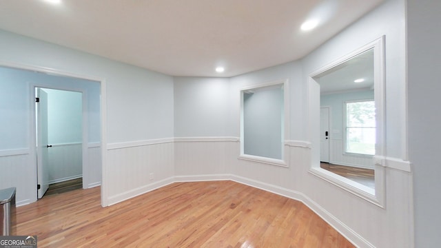 unfurnished room featuring light wood-type flooring, a wainscoted wall, and recessed lighting