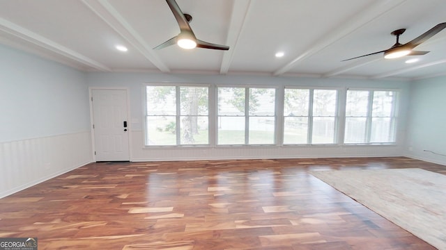 interior space featuring a healthy amount of sunlight, wood finished floors, a ceiling fan, and beamed ceiling