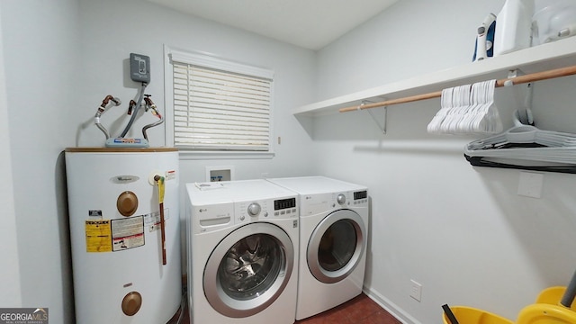 clothes washing area featuring water heater, laundry area, dark tile patterned flooring, and independent washer and dryer