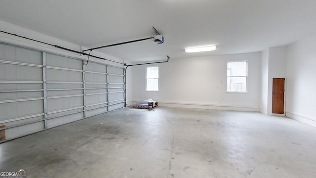 garage with baseboards and a garage door opener