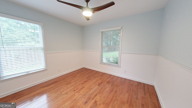 empty room featuring ceiling fan, baseboards, and wood finished floors