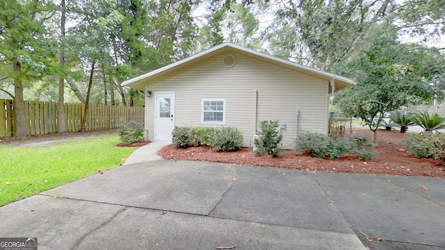 view of side of home with fence and a lawn