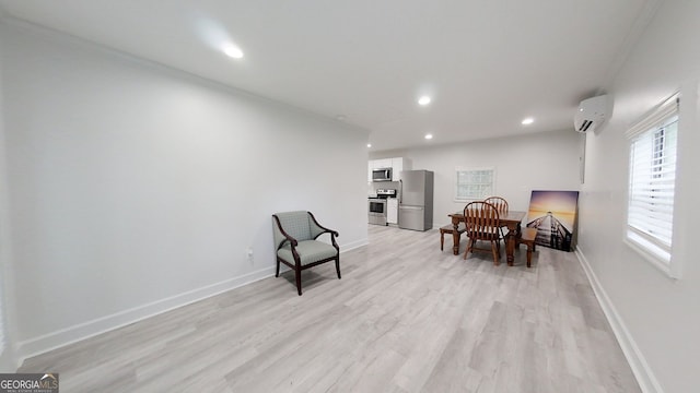 living area with recessed lighting, baseboards, a wall mounted air conditioner, and light wood finished floors