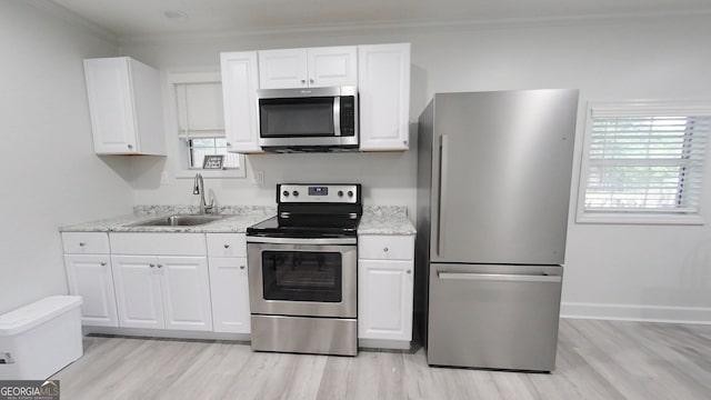 kitchen with stainless steel appliances, white cabinets, and a sink