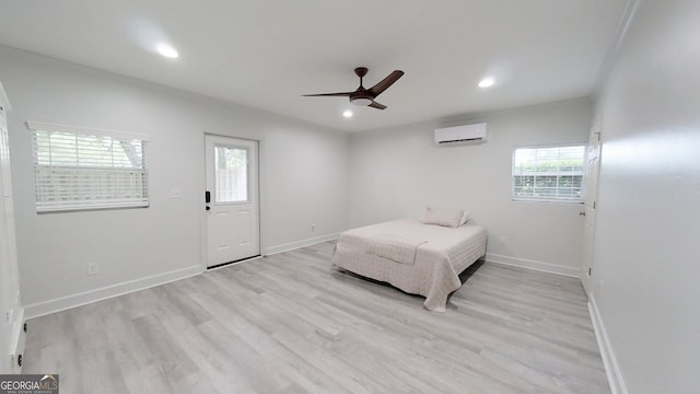 bedroom featuring light wood finished floors, multiple windows, and baseboards