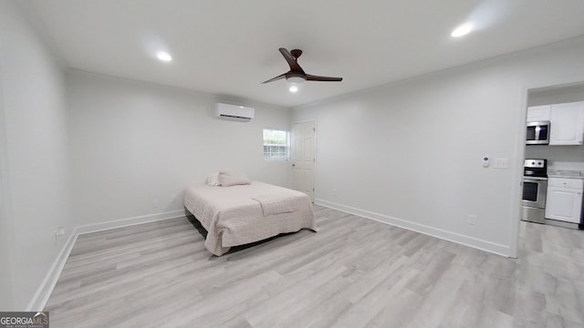 bedroom featuring recessed lighting, a wall mounted AC, light wood-type flooring, and baseboards