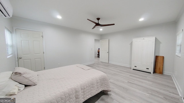 bedroom featuring light wood-style floors, recessed lighting, baseboards, and a wall mounted AC