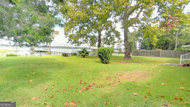 view of yard with a water view and fence