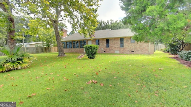 exterior space featuring a yard, brick siding, crawl space, and a fenced backyard