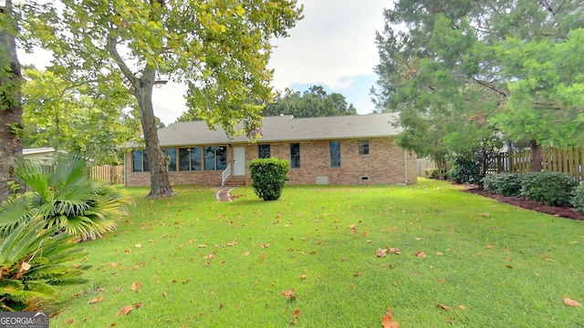 view of front facade with entry steps, brick siding, fence, crawl space, and a front lawn