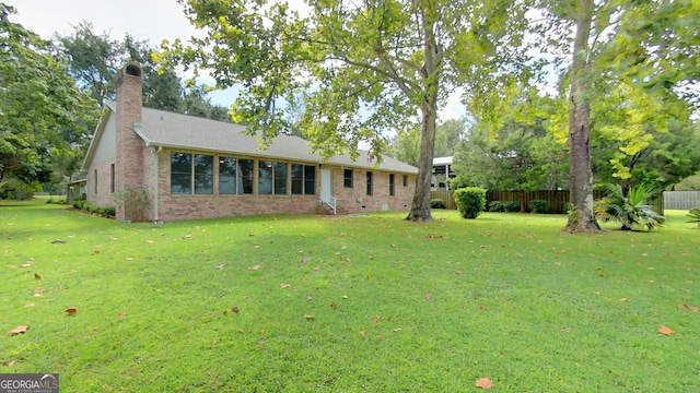 view of front of property with a chimney, crawl space, fence, a front lawn, and brick siding