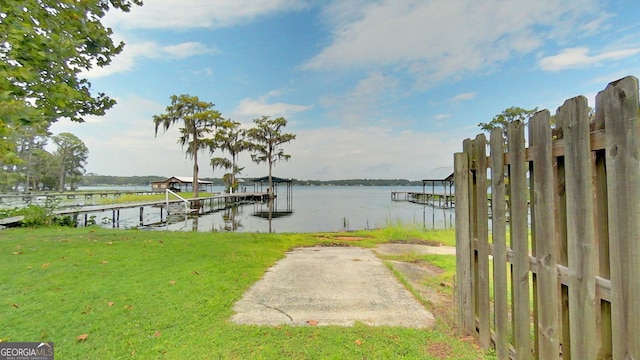 dock area featuring a water view and a lawn