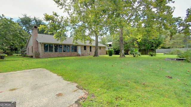 view of front of property with a chimney, a front yard, and fence