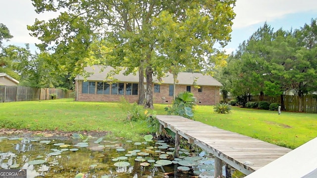 dock area featuring a fenced backyard and a lawn