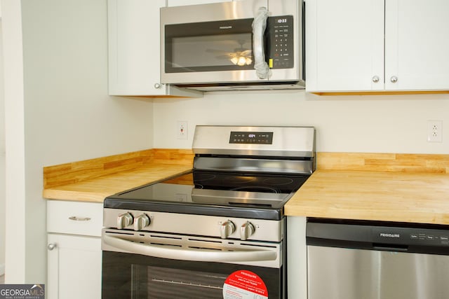 kitchen featuring appliances with stainless steel finishes, white cabinets, and a ceiling fan