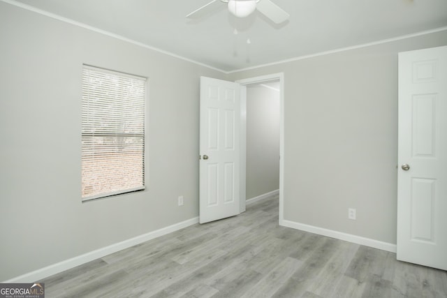 unfurnished bedroom with ornamental molding, light wood-type flooring, and baseboards